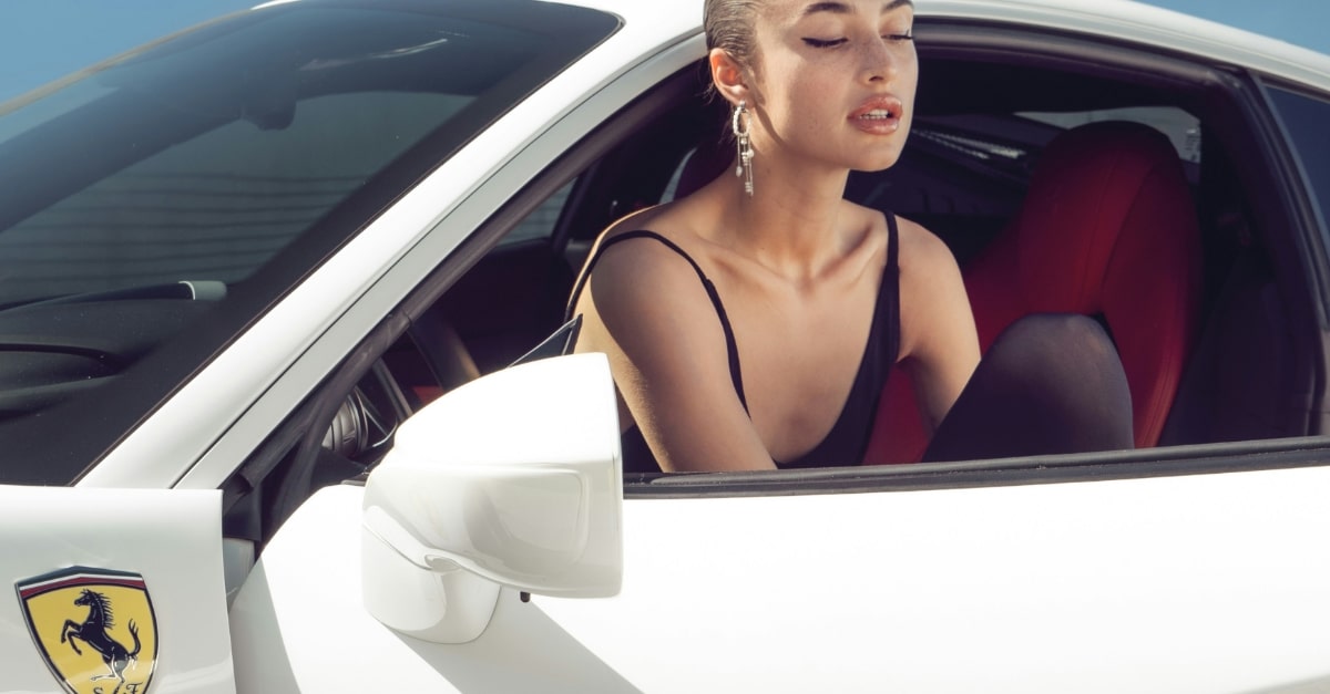 Model climbing out a sports car